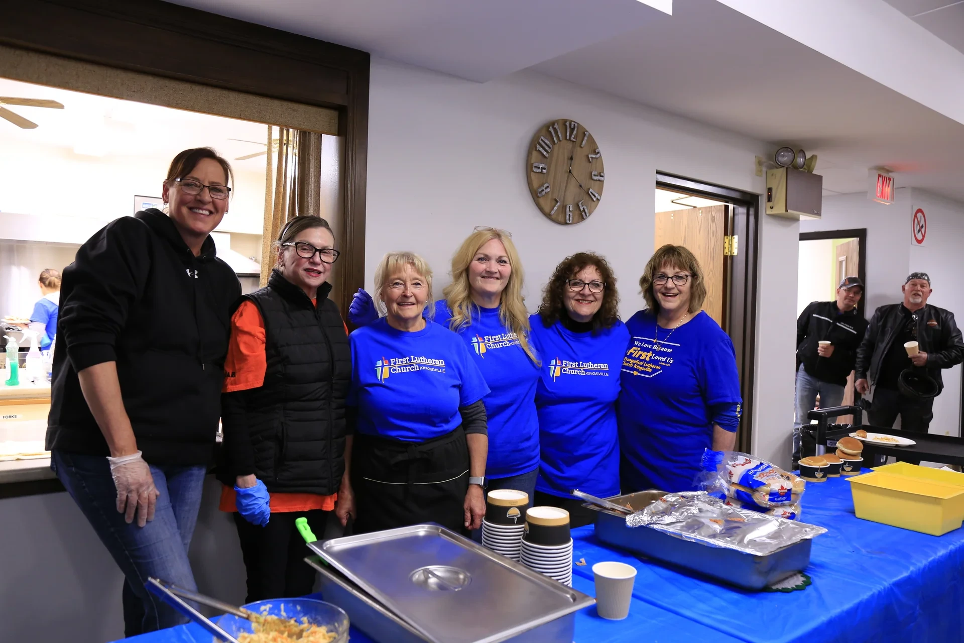 First Lutheran volunteers serving at an indoor community table